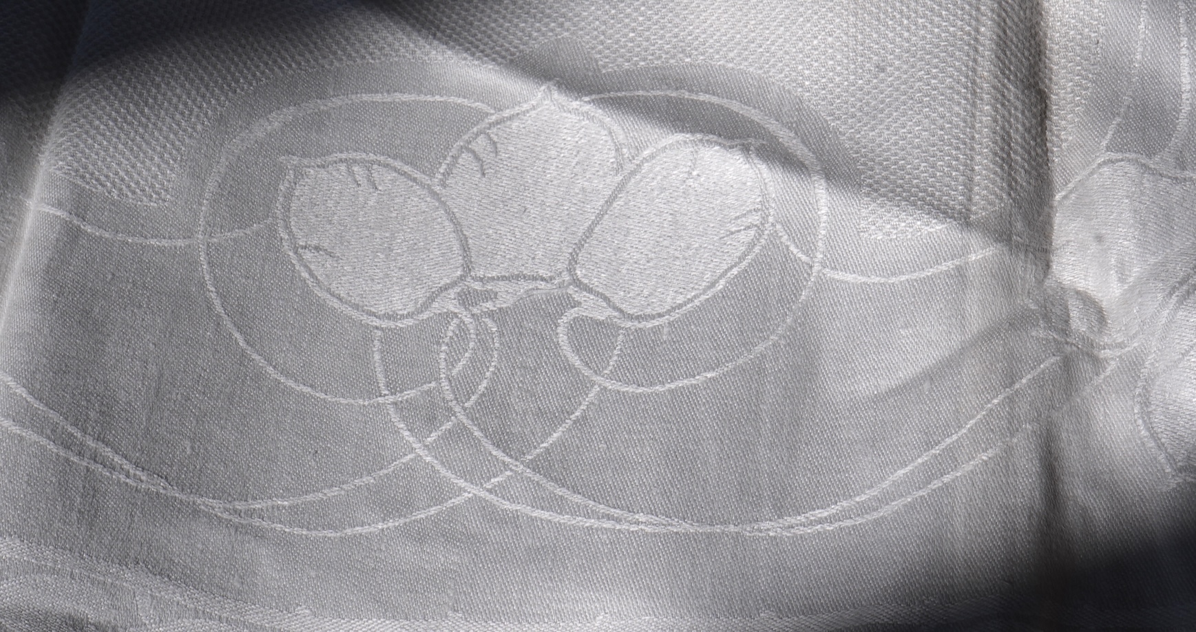 A set of four large Art Nouveau, unused white damask woven hand towels. The pattern having strong Archibald Knox and Walter Crane design elements; with trailing Honesty seeds and Tulip flower heads, these motifs much use